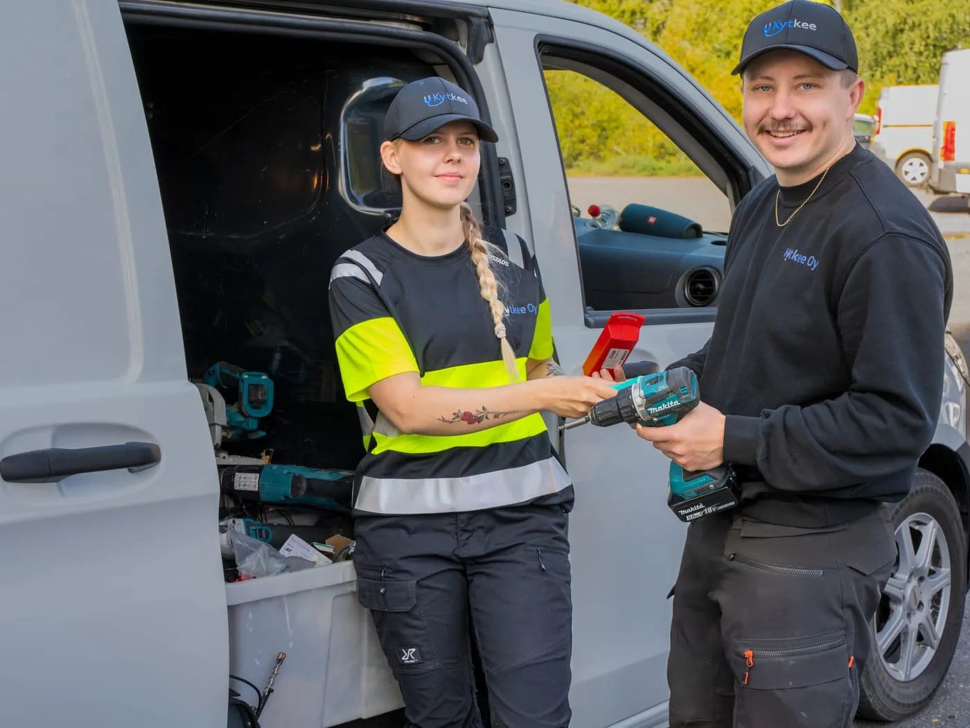 Kytkeen asentajat työkalujen kanssa pakettiauton takana